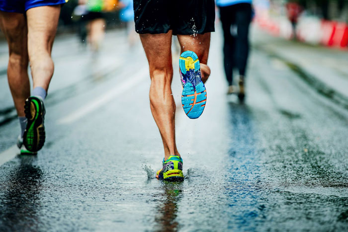 Athletes running on wet concrete